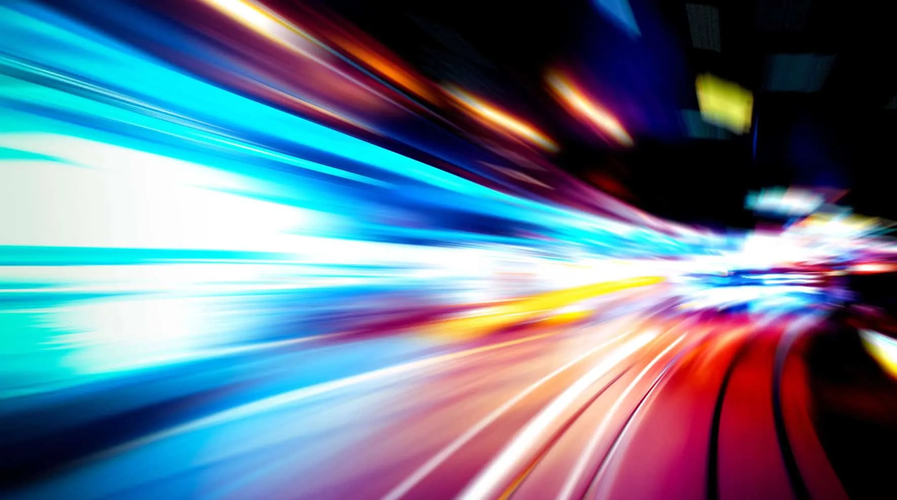 Colorful light trails from a long exposure, suggesting speed