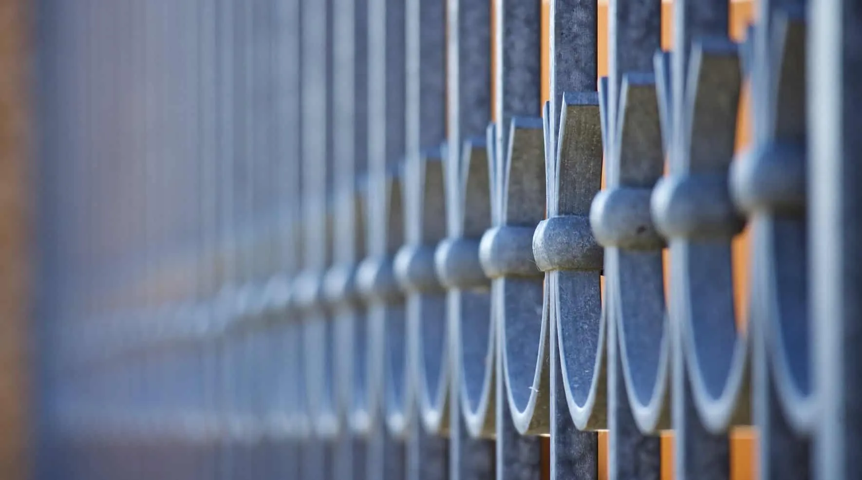 Metal fence with vertical bars receding into the distance