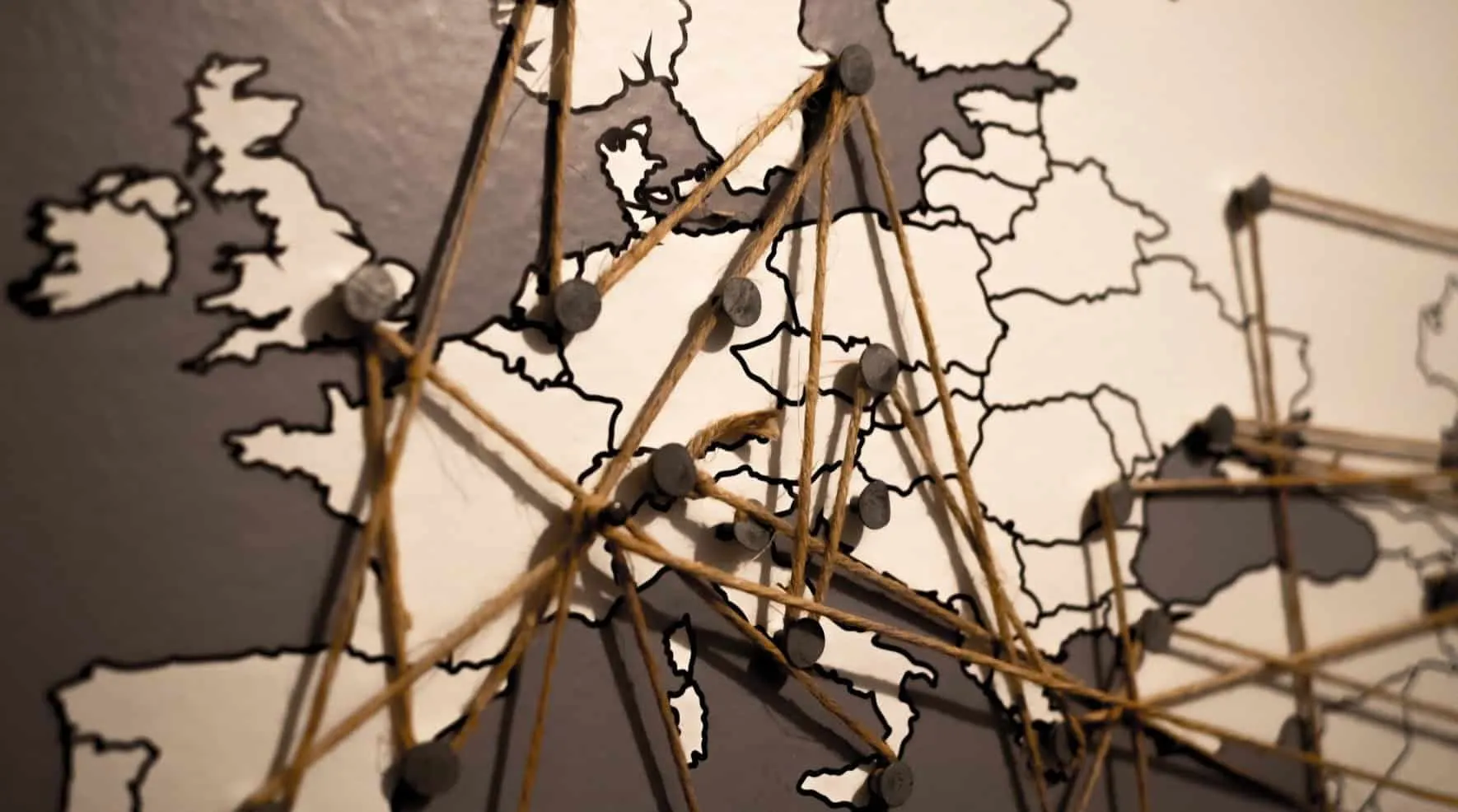 Map of Europe on a wall with threads strung between pins