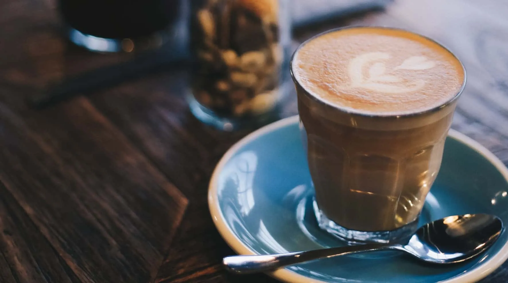 Glas Cappuccino auf blauer Untertasse neben einem Löffel – Java 21 Features