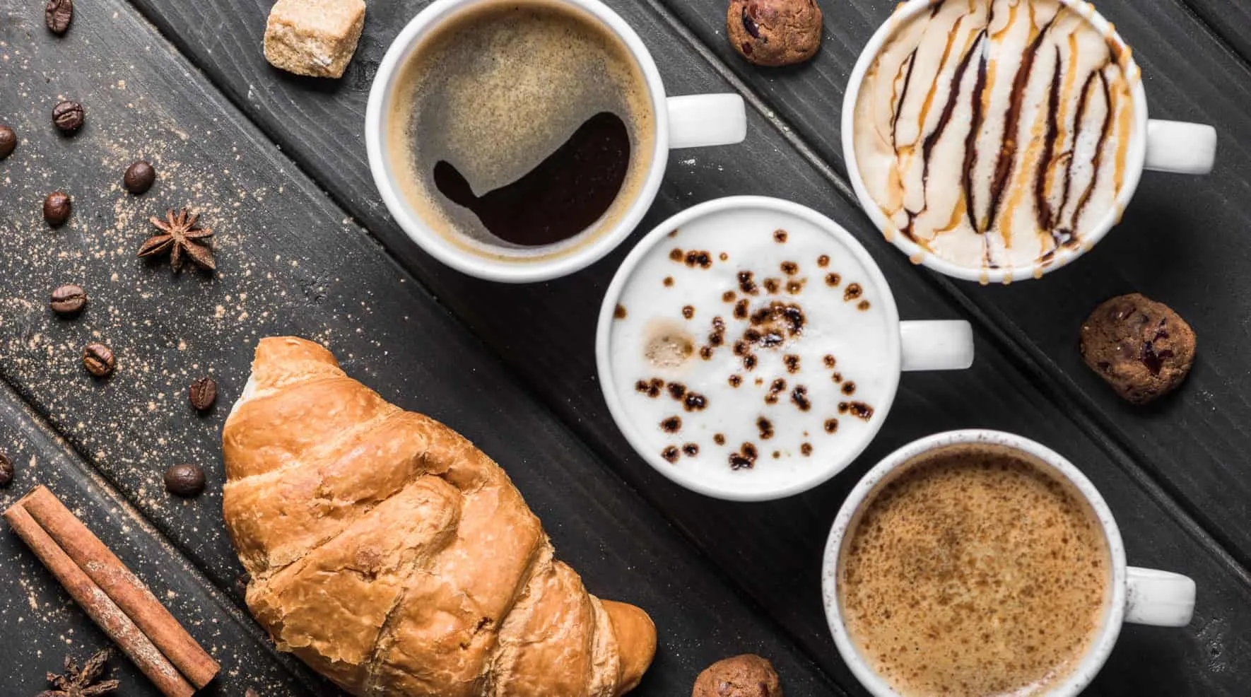 Vier verschiedene Kaffeespezialitäten mit Croissant und Gebäck von oben – Java 24 Features