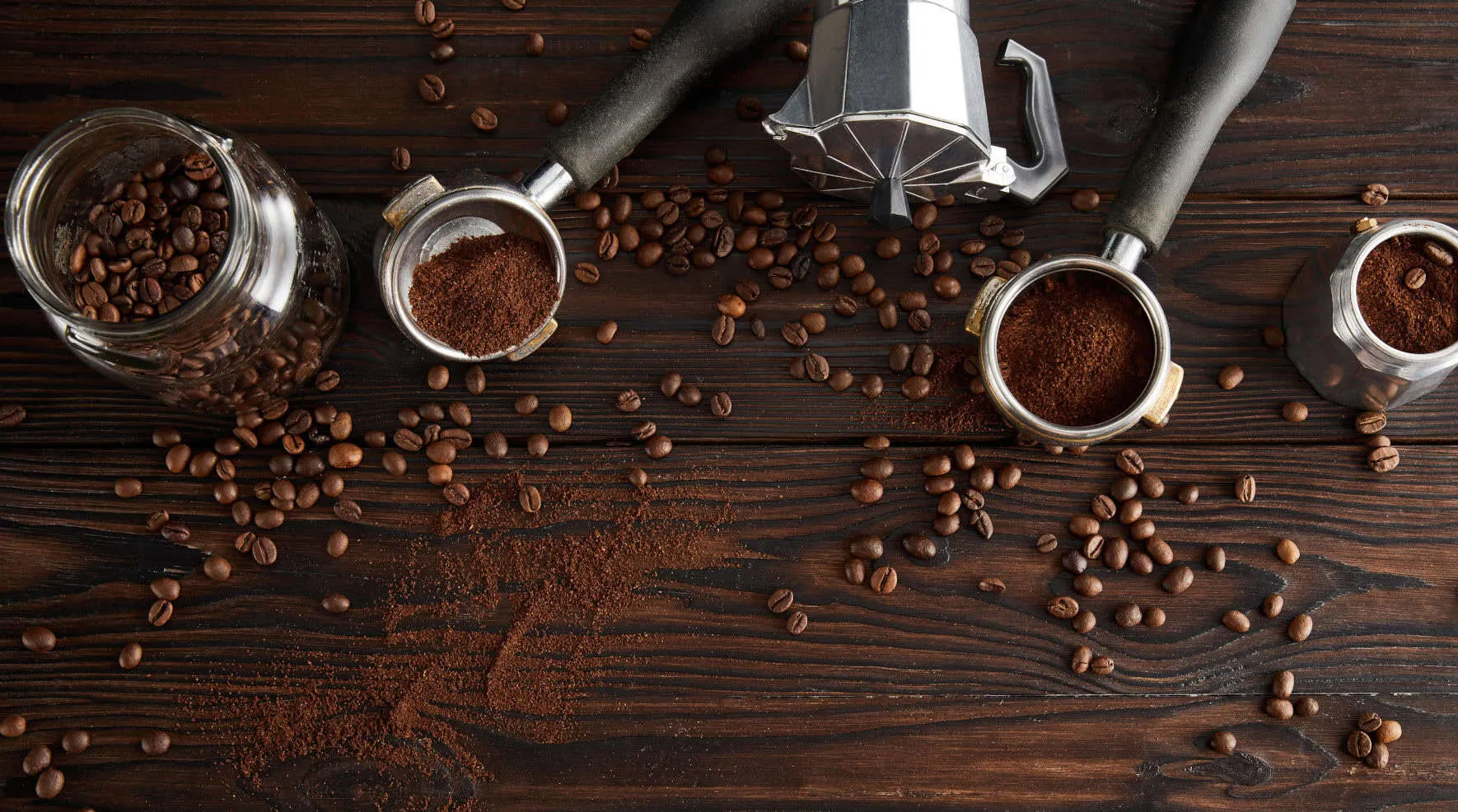 Portafilters, a moka pot and coffee beans on dark wood – Java 26 Features