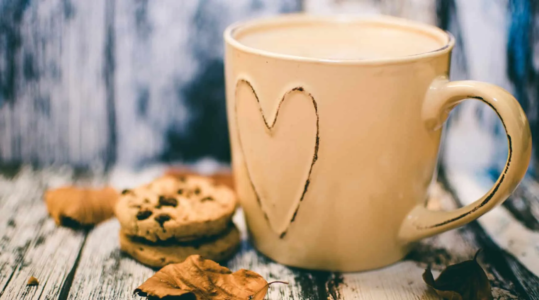 Large cup of milk coffee with a heart drawn on it, next to cookies – Java 27 Features
