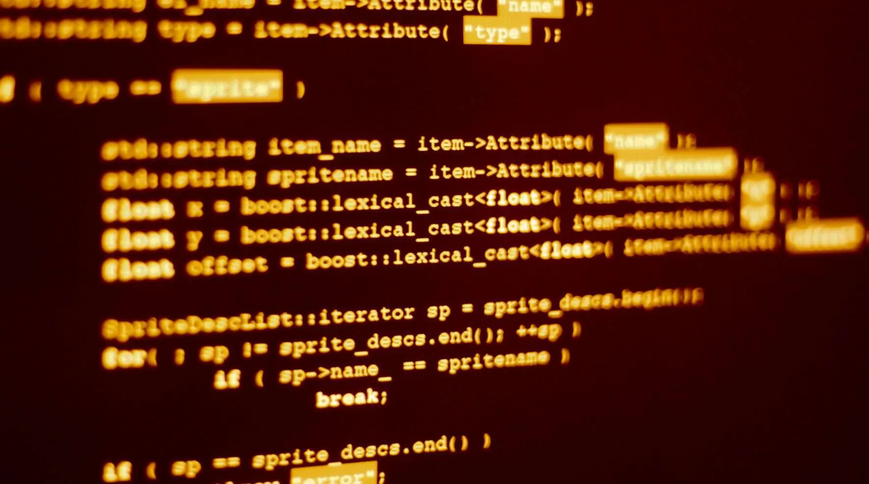 Quellcode in Orange auf schwarzem Bildschirm, in Nahaufnahme