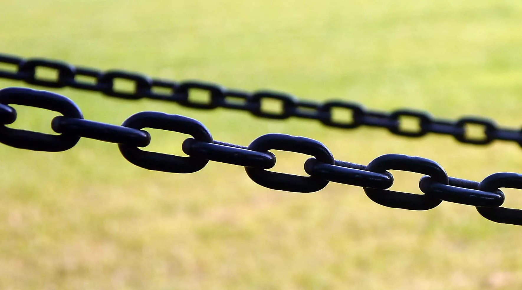 Black chain stretched across a meadow