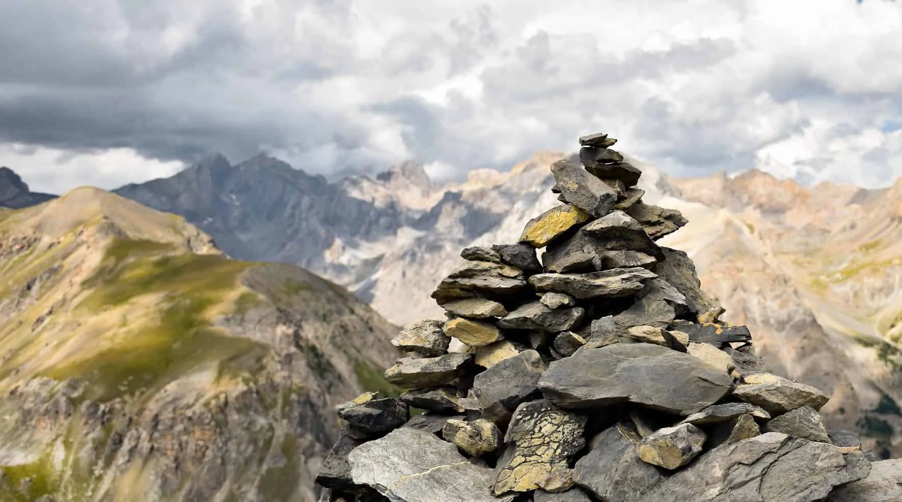 Cairn of stacked stone slabs on a mountain summit
