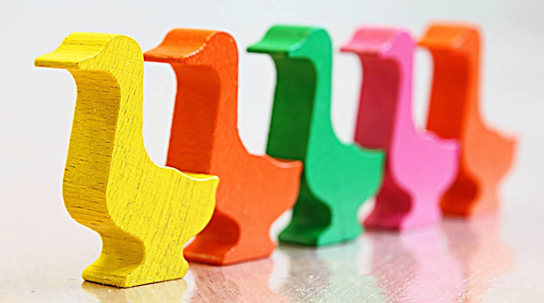 Five colorful wooden ducks in a row