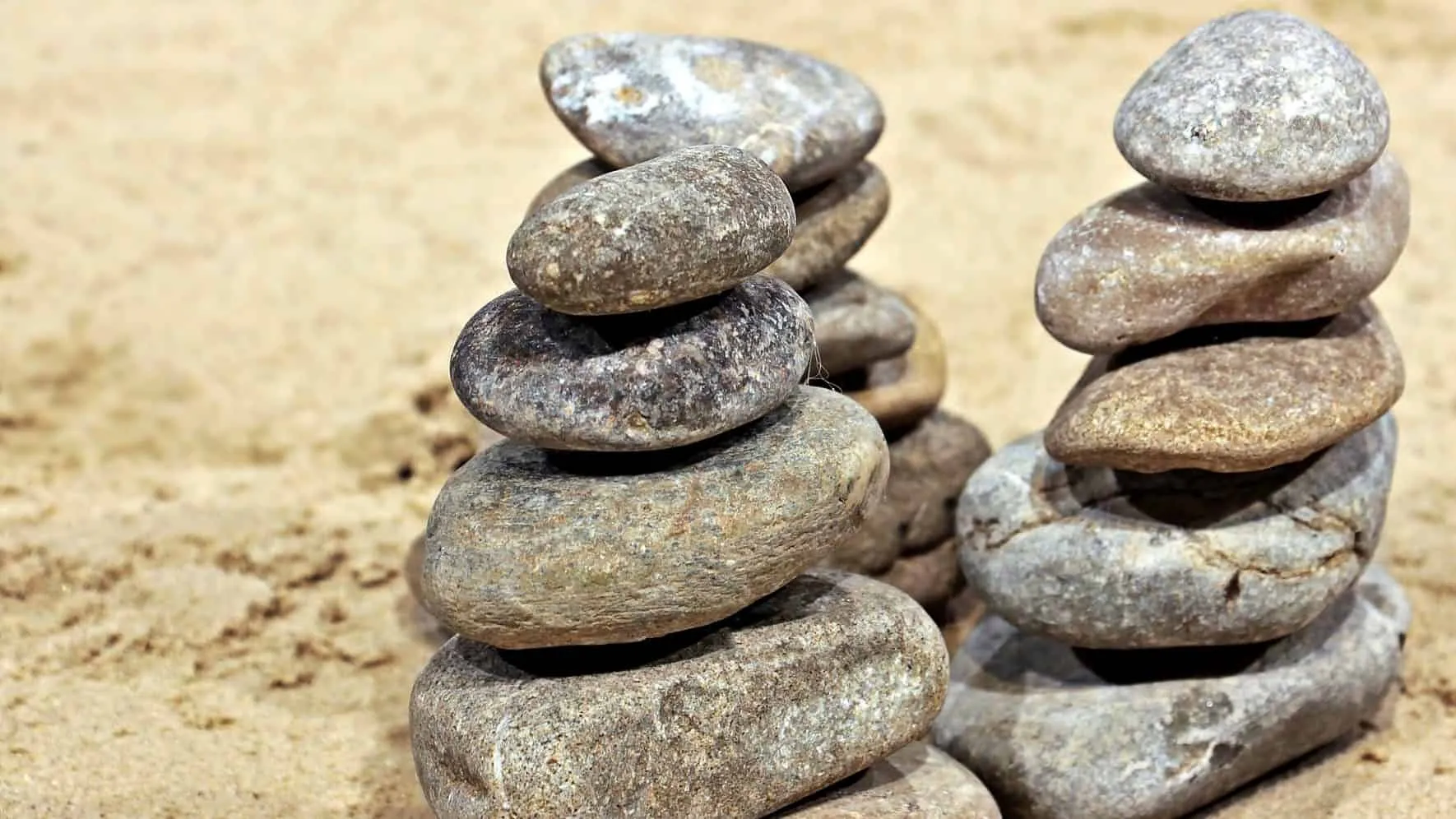 Two towers of stacked pebbles in the sand