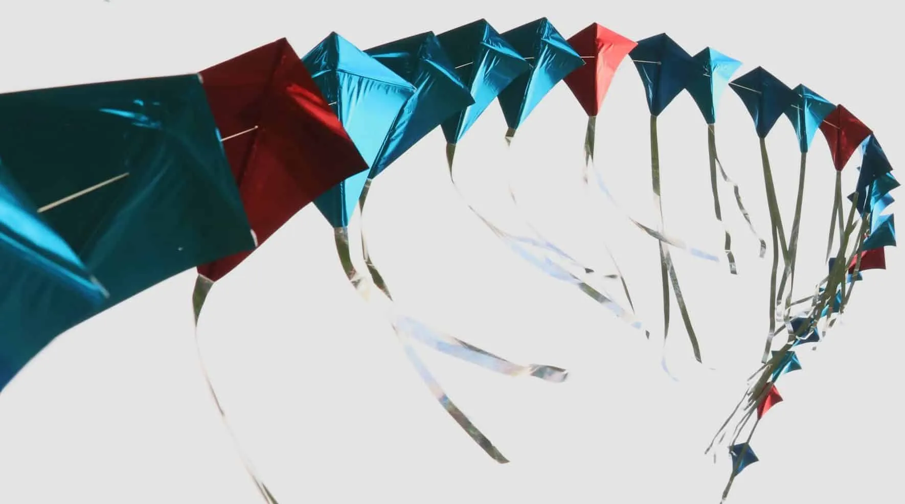Row of foil kites against a white background